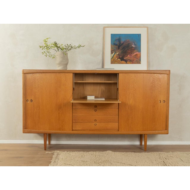 Classic highboard from the 1960s by H.W. Klein for Bramin. High-quality oak veneer body with two sliding doors, four...