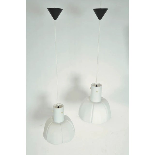 A good pair of stylish 1970s moulded matt opaline glass pendants in the form of stylised flowers, from the renowned german...