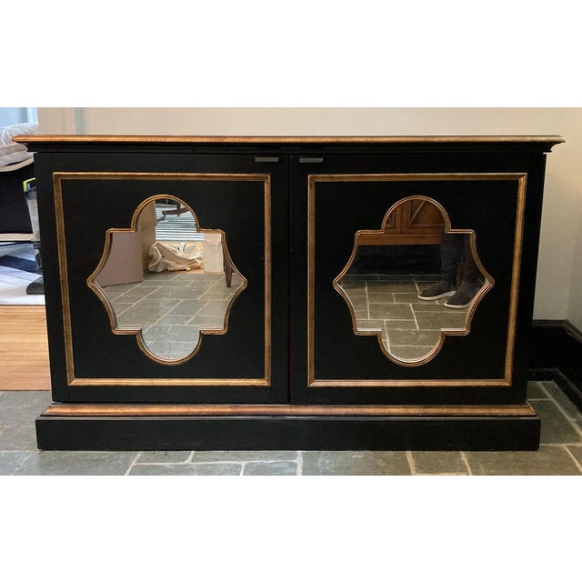 Lovely cabinet in a black finish, trimmed in gilt trim and ogee-shaped antiqued mirror. Inside reveals two adjustable...