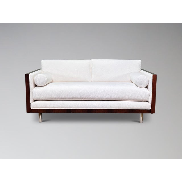 A soft patterned chenille seating form is encased in a breathtaking rosewood shell which floats atop four polished chrome...