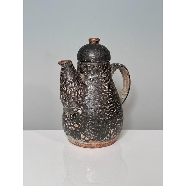 This handcrafted coffee pot by the German ceramicist Helma Klett (1908-1996) showcases the characteristic rustic aesthetic...