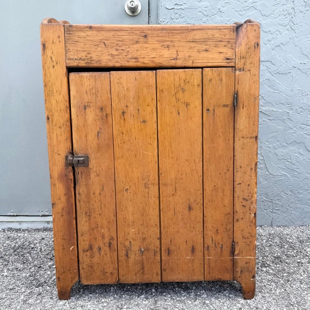 A charming antique primitive storage cupboard crafted from solid wood with a beautifully aged warm honey-brown finish. The...