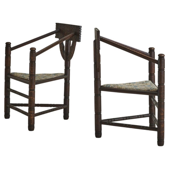 An early 20th-century Swedish primitive monk chair, crafted from solid oak and defined by its deeply carved surfaces and...
