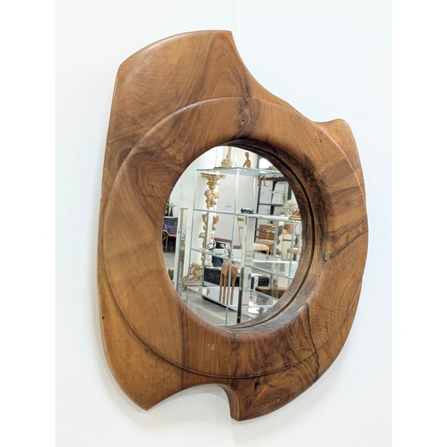 French wall mirror produced in the 1960s. The frame is carved from solid walnut, featuring an organic and asymmetrical...