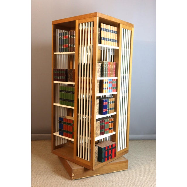 Rare rotating bookcase in light oak and painted finish. This bookcase pivots on its base, which is equipped with casters....