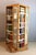 Rare rotating bookcase in light oak and painted finish. This bookcase pivots on its base, which is equipped with casters....