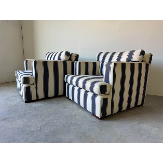 Elegant and exceptionally comfortable, this pair of Ralph Lauren arm lounge chairs features a timeless navy-and-white...