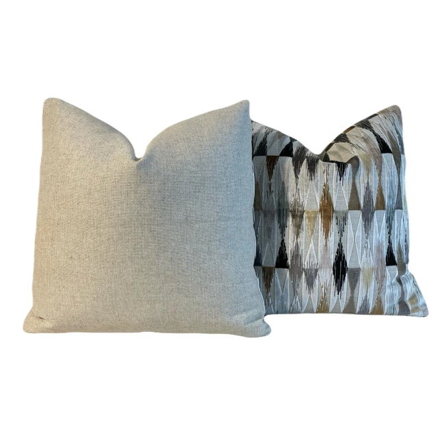 This pair of pillows feature Osborne and Little “Landsdowne Colville Charcoal” fabric on the front with Schumacher...