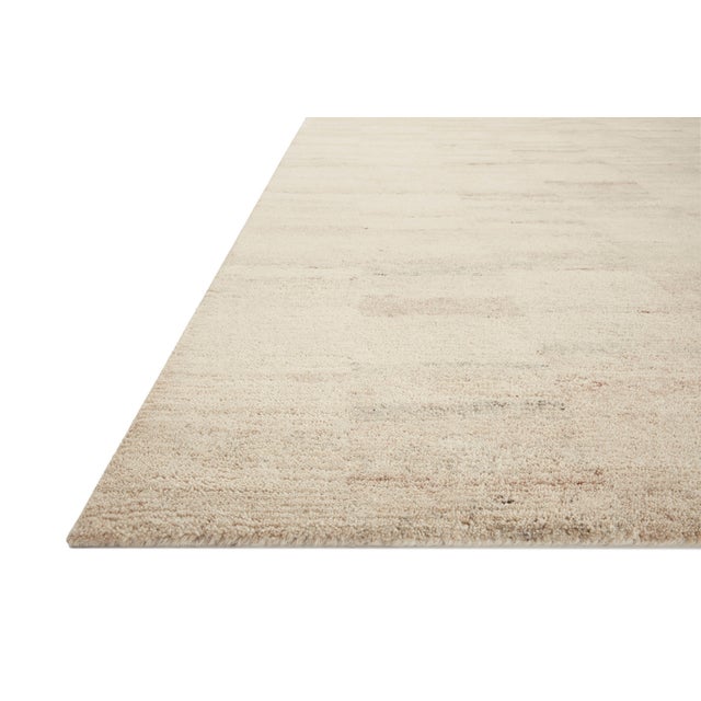 The Rocky Collection area rug by Amber Lewis x Loloi is uniquely hand-tufted with undyed wool to create a subtle and...
