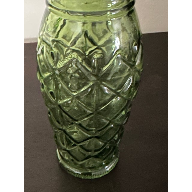 Vintage 1960s green pressed-glass vase with a scalloped rim and molded floral/geometric decoration. Approximately 2” x 2”...
