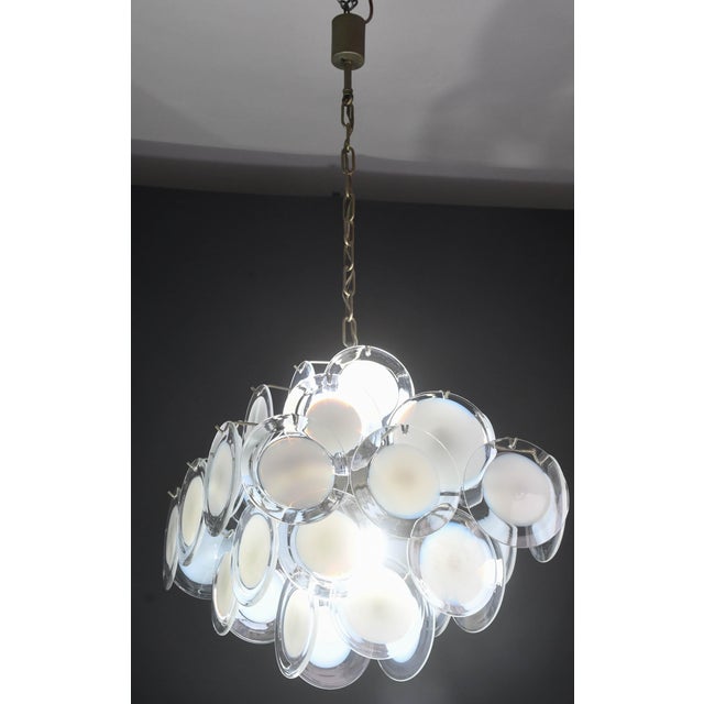 A spectacular Murano chandelier comprising 36 white glass discs. The chandelier features five tiers of discs; the...