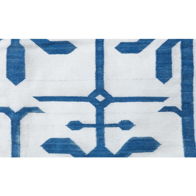 This striking Indian Dhurrie rug presents a crisp, sun-washed palette of blue and white, offering a clean, uplifting...