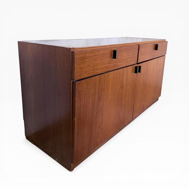 A stylish mid-century Danish teak low sideboard, showcasing the clean lines and understated elegance characteristic of...