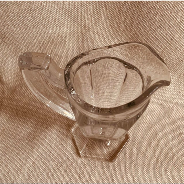 A stunning example of late 19th-century American glassmaking, this elegant pitcher showcases the refined neoclassical...