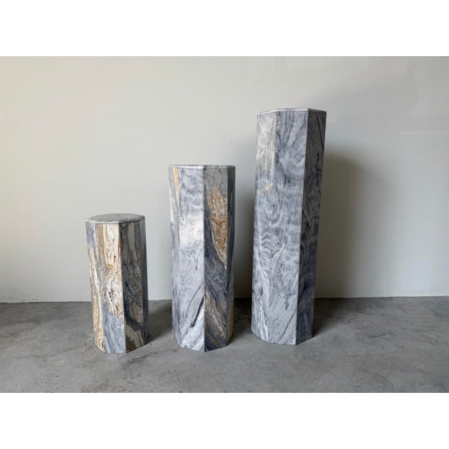 Striking set of three 1980’s Postmodern octagonal marble pedestals, featuring bold geometric lines and dramatic natural...