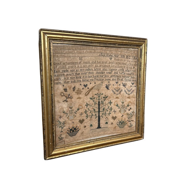 This framed 1830 sampler has a depiction of Adam & Eve in the garden of Eden. Plants, birds and hearts decorate this...