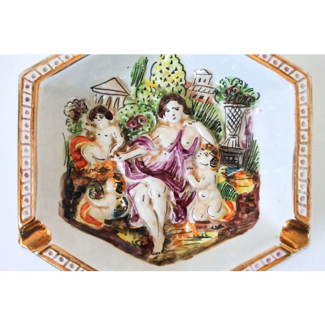 Highly dimensional cherub figures. Marked on the bottom Capodimonte. Made in Italy. Some age wear to painted finish. No...