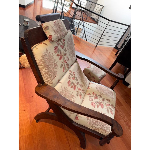 Beautiful vintage wooden armchair featuring gently curved arms and a solid, well-built frame. The chair is upholstered in...