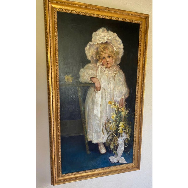 A beautifully executed late 19th-century oil portrait depicting a young girl in a white bonnet, presented in its...