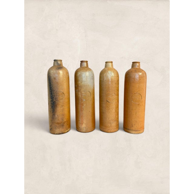 Four salt-glazed stoneware bottles that once held mineral water, schnapps, or gin on the shelves of European merchants and...