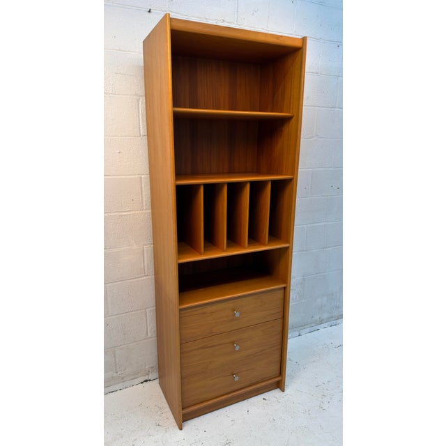 Vintage Danish modern bookcase crafted in warm-toned teak, featuring a streamlined silhouette with gently curved side...