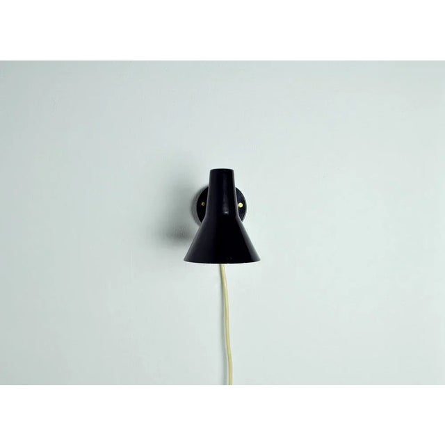 Scandinavian Modern Danish wall lamp with adjustable brass arm. Black lacquered metal. Inner shade white. Very good...