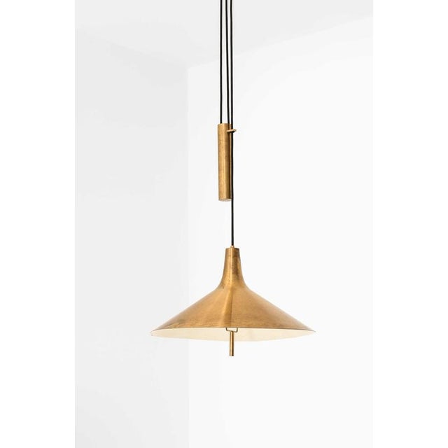 This rare height-adjustable ceiling lamp, designed by thomas valentiner and produced by poul dinesen in denmark, is a...