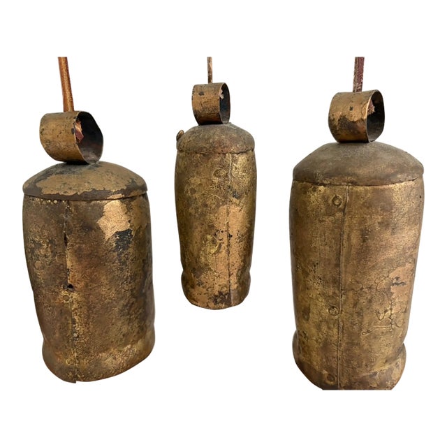 Set of vintage cast brass bells with a heavy, solid feel and aged patina. These have a simple cylindrical form with iron...