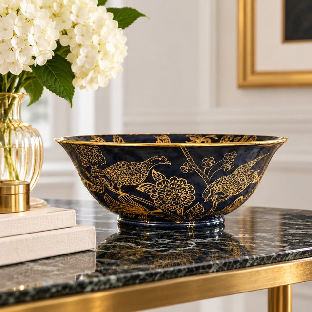 Elegant decorative bowl featuring a rich navy blue ground with an intricate gilt chinoiserie design depicting quail,...