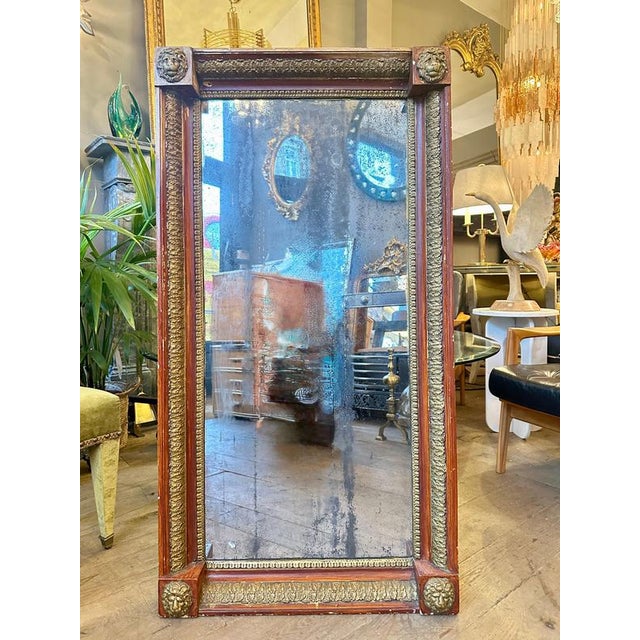 A giltwood and hand painted pier mirror from the Italian Empire period. Decorated with lion masks on the corners and...