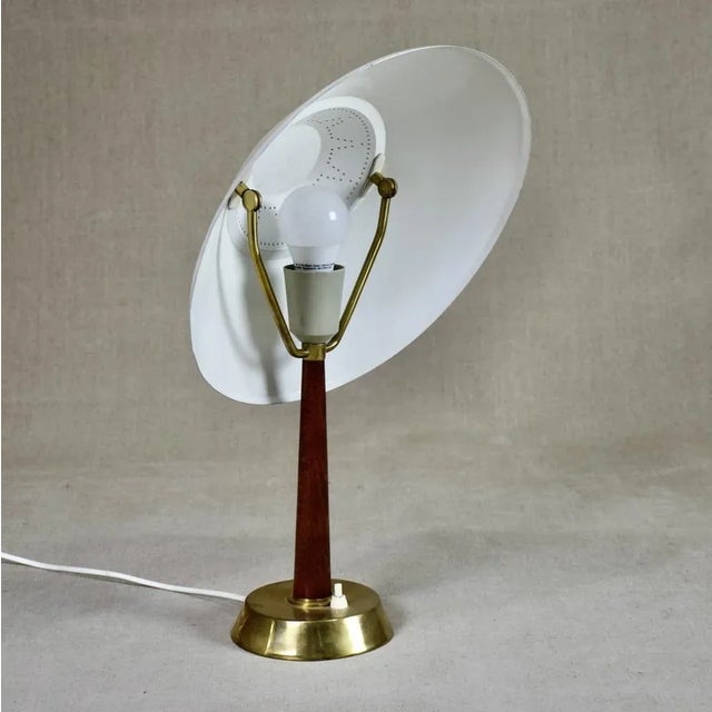 Rare table / desk lamp in brass, mahogany-stained birch and the shade in pained metal. Adjustable shade. This piece has an...