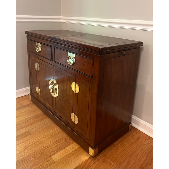 Elevate your dining or living space with this exceptional vintage Chinoiserie-style rolling bar cabinet and server by...