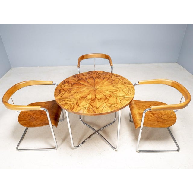 A refined Czechoslovak functionalist dining set consisting of three armchairs and one round table, attributed to the...