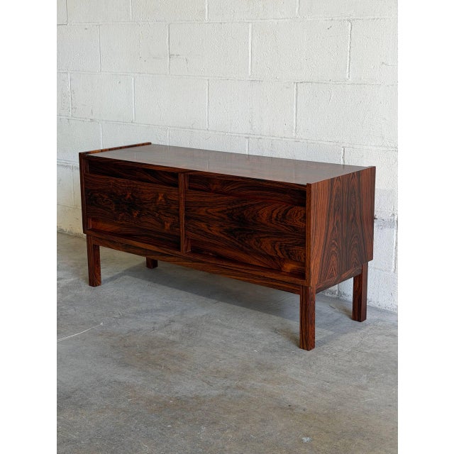This stunning low storage unit exhibits a rectangular form with clean geometric contours. Four wide parallel drawers glide...