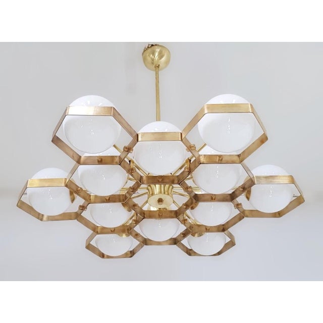 Italian modern chandelier with glossy white Murano glass globes, mounted on solid brass frame in unlacquered natural brass...