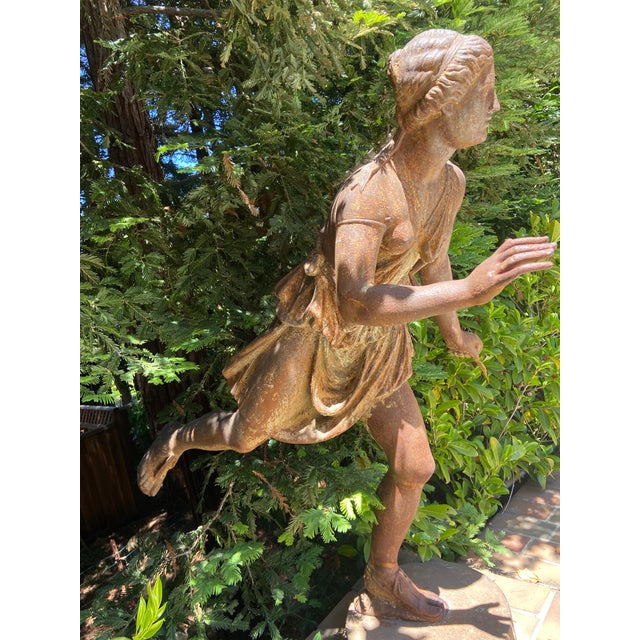A cast iron 19th century French statue of Artemis, the huntress. The sculpture captures the huntress in motion, and...