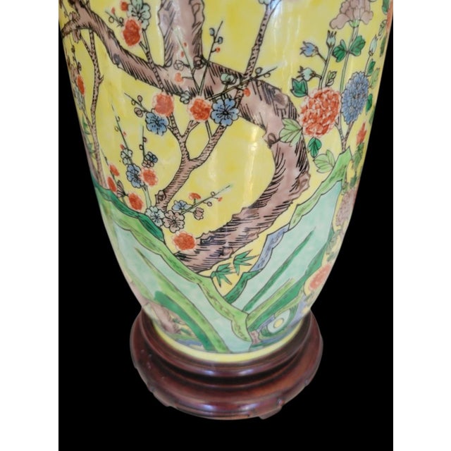A stunning pair of vintage Chinoiserie ceramic large yellow, blue cherry blossom table lamps. The lamps feature a...