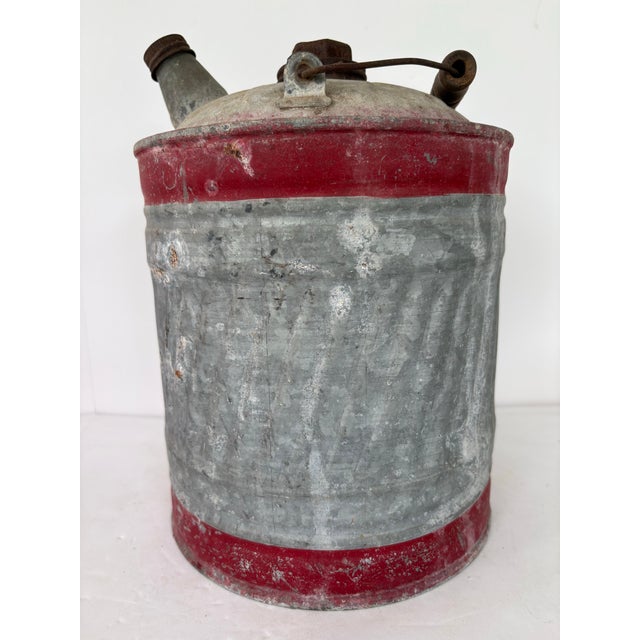 This vintage galvanized metal oil can dates from the 1930s–1940s and showcases classic early-industrial American design....