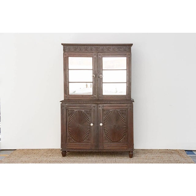 This captivating two-part cupboard exemplifies the fusion of European and Indian aesthetics characteristic of Indo-...