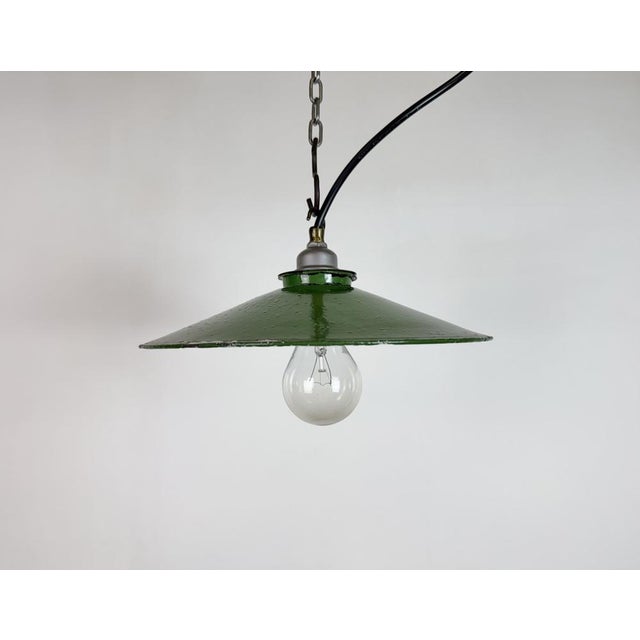 Vintage industrial enamel pendant lamp from the 1950s. It features a green enamel shade with white enamel interior and a...