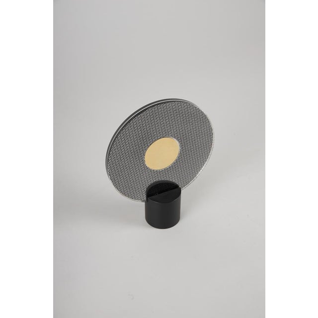 Photo frame with a black-painted metal base and two plastic discs featuring screen-printed acetate. Manufactured by danese...