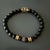 The Onyx Fleur De Lis Beaded Bracelet is a stunning piece of handmade jewelry that features black onyx stone beads strung...