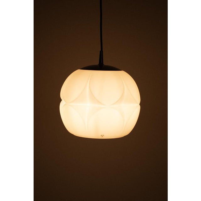 Wonderfully shaped vintage hanging lamp by Peill & Putzler from Germany, 1960s. The lamp is made of white matte glass with...