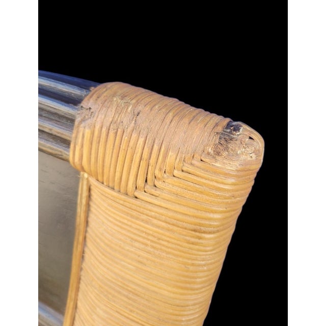 A wonderful wicker and dark wood traditional or British Colonial rocking chair. The chair features solid bent dark stained...