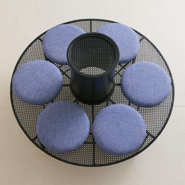 A 1950s French circular iron garden bench, designed as a sculptural ring with six round cushions upholstered in a soft...
