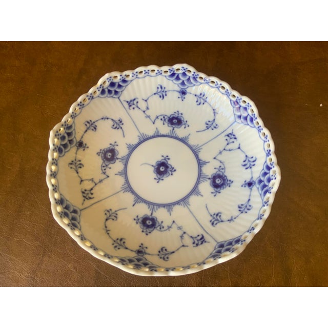highly collectible porcelain piece in hand painted cobalt blue design and distinct open work laced border along the rim.