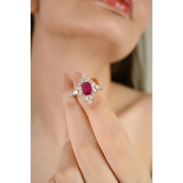 This Art Deco–inspired cocktail ring is crafted in 18K white gold, featuring a vibrant 1.08 carat emerald-cut ruby at the...