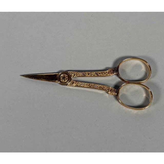 A pair of 18th-century 18k (750/1000) yellow gold sewing scissors. Decorated with chased rose motifs on a background...