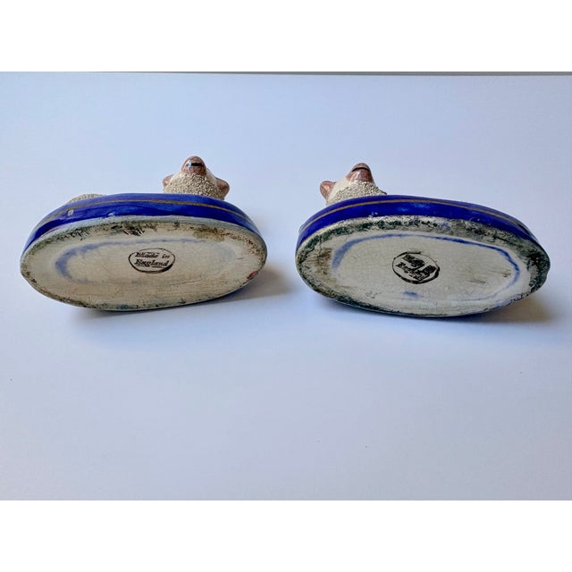 Quality pair of antique Staffordshire sheep ink wells. They feature a classic confetti glaze and lay on a blue and gold base.