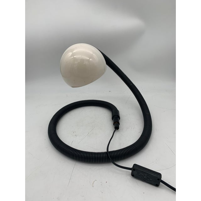 Table lamp with a vintage design with a serpentine base covered with a corrugated tube that is neither broken nor cracked...